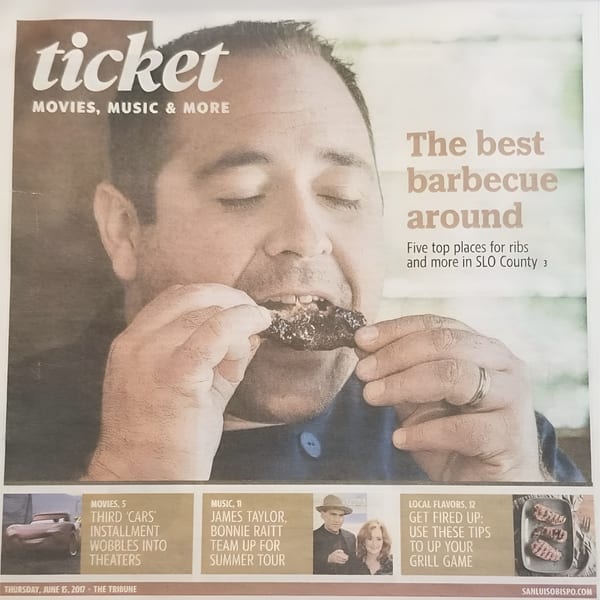 Man with closed eyes happily eating a Ribline BBQ rib, featured on a newspaper cover.